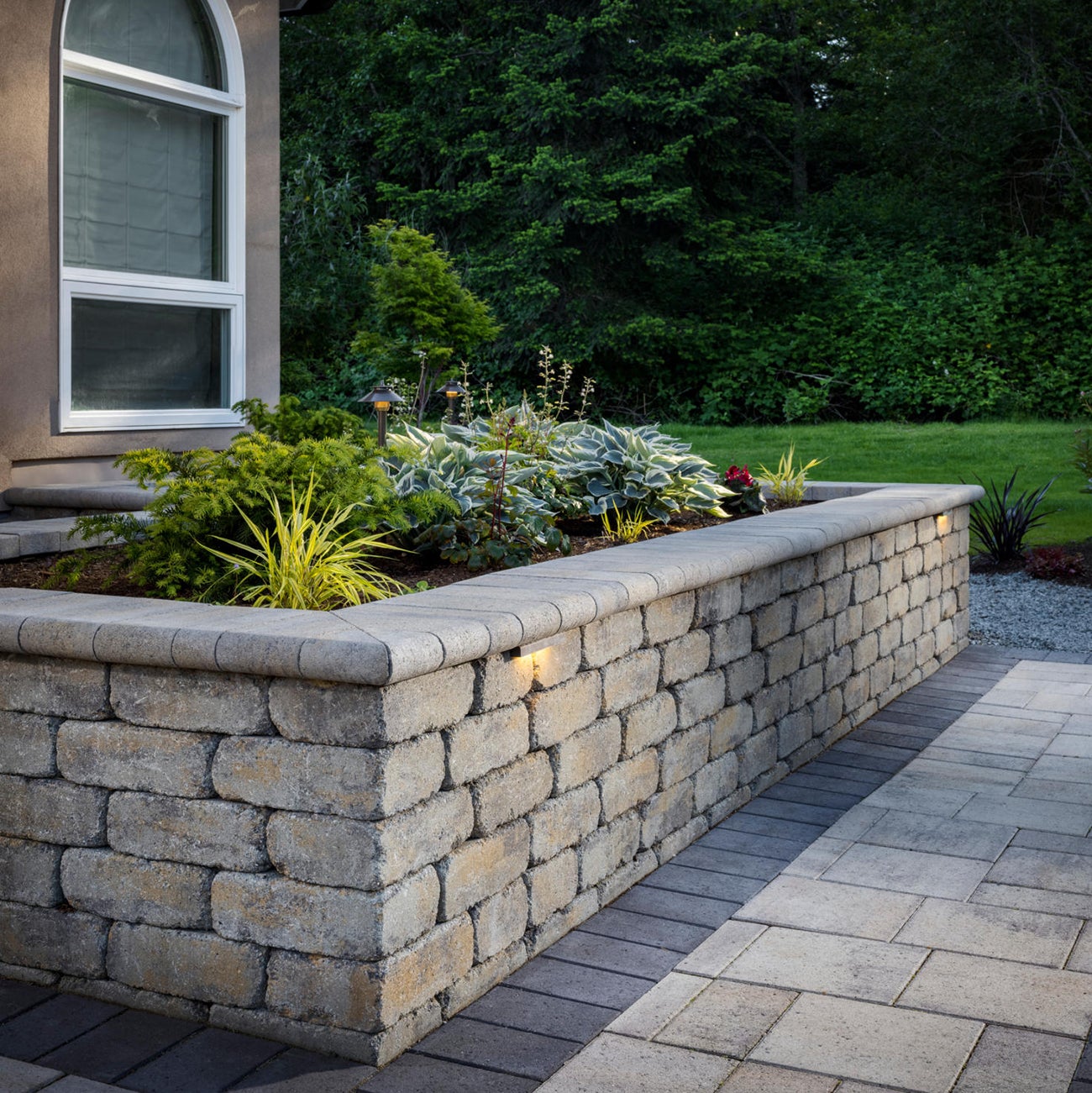 A chic retaining wall adding structure and style to a beautifully landscaped yard.