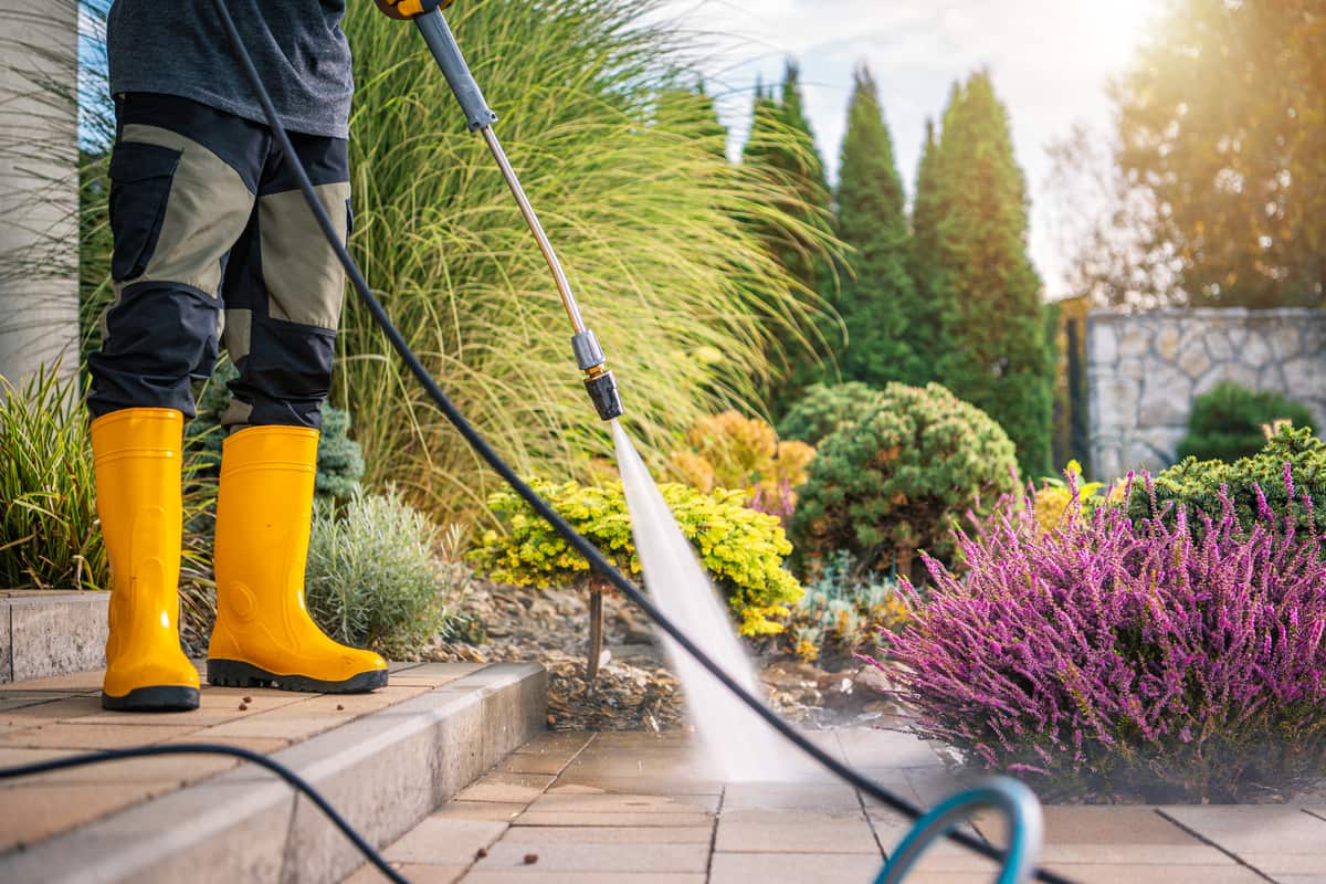 A homeowner freshening up her patio stones with a gentle pressure wash.